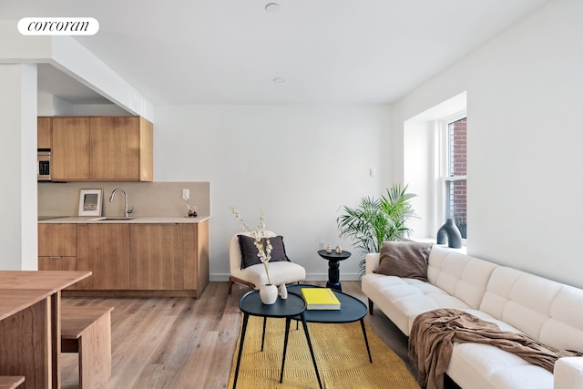 living area featuring light wood-style flooring and baseboards