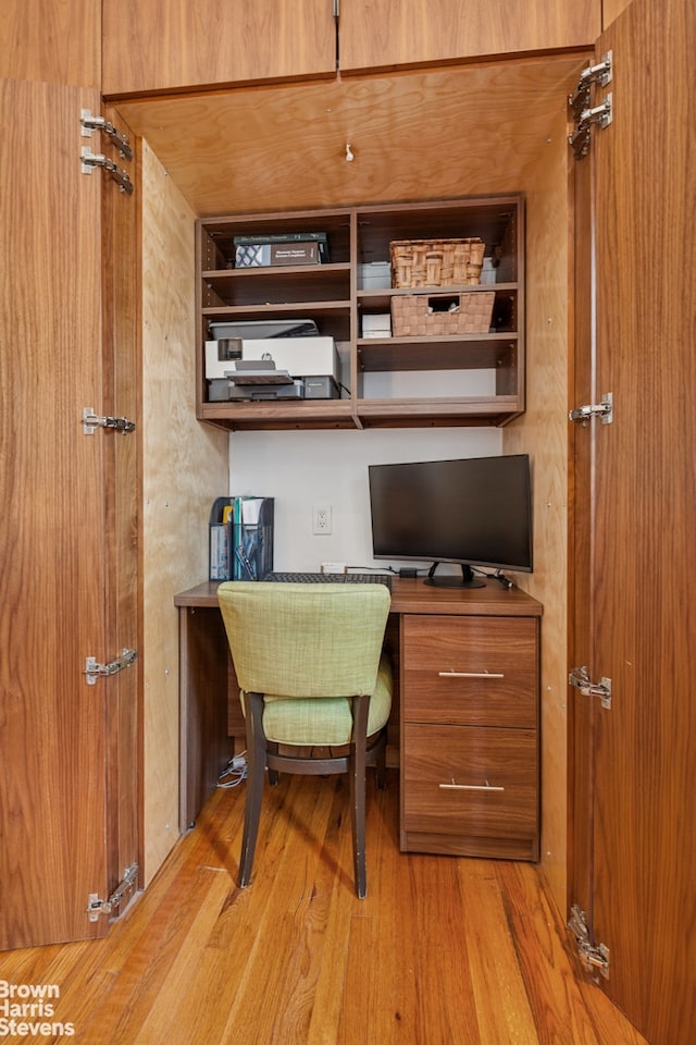 office space with built in desk and wood finished floors
