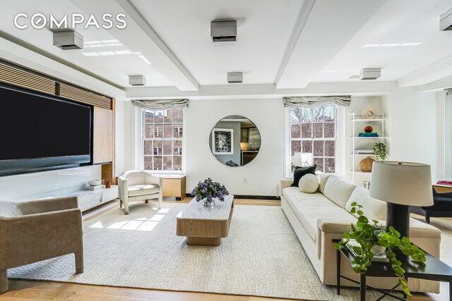 living room with wood finished floors and beamed ceiling