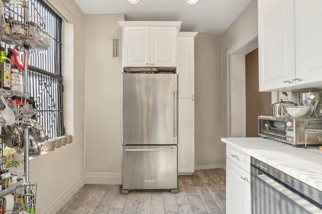 725 Riverside Dr Unit 8-D, New York City, NY 10031 - kitchen featuring appliances with stainless steel finishes, light countertops, baseboards, light wood-type flooring, and visible vents