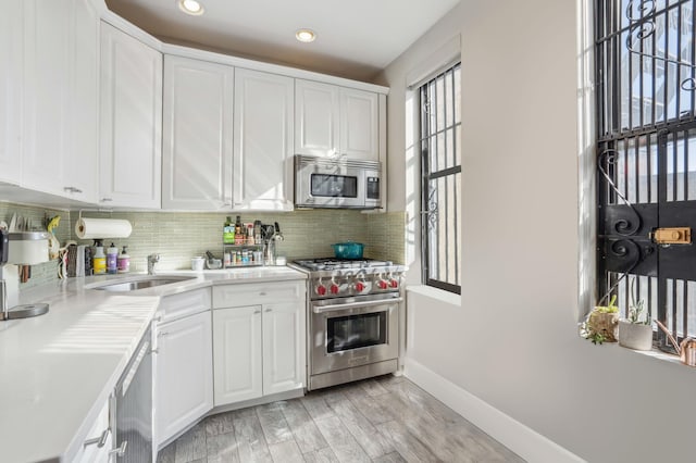 725 Riverside Dr Unit 8-D, New York City, NY 10031 - kitchen with a sink, white cabinetry, and appliances with stainless steel finishes