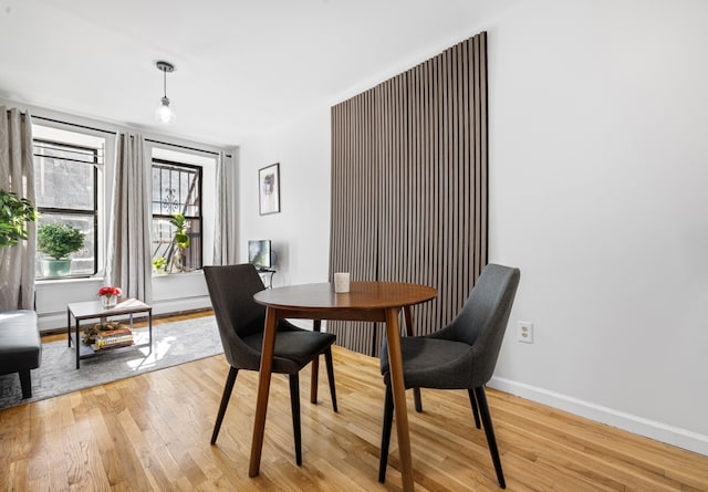 dining area with baseboards and light wood-style flooring
