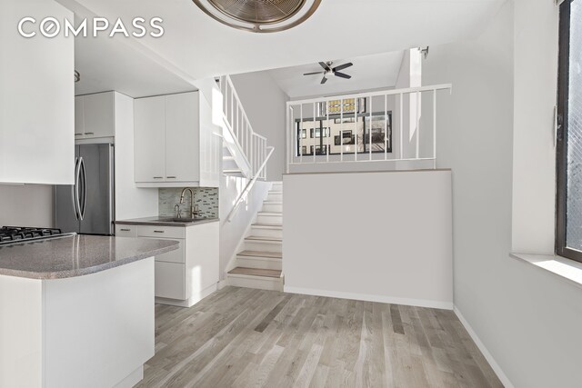 unfurnished room with baseboards, wood finished floors, and ceiling fan
