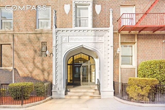 entrance to property featuring brick siding