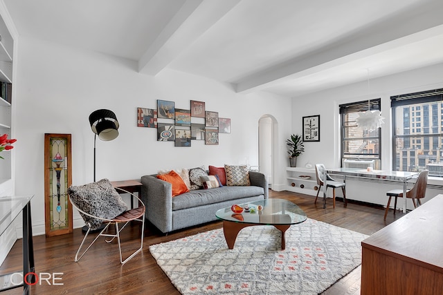 living room featuring arched walkways, baseboards, beam ceiling, and wood finished floors