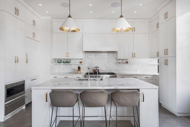 260 Park Ave S Unit 9Bc, New York City, NY 10003 - kitchen with a warming drawer, backsplash, light stone countertops, decorative light fixtures, and a kitchen bar