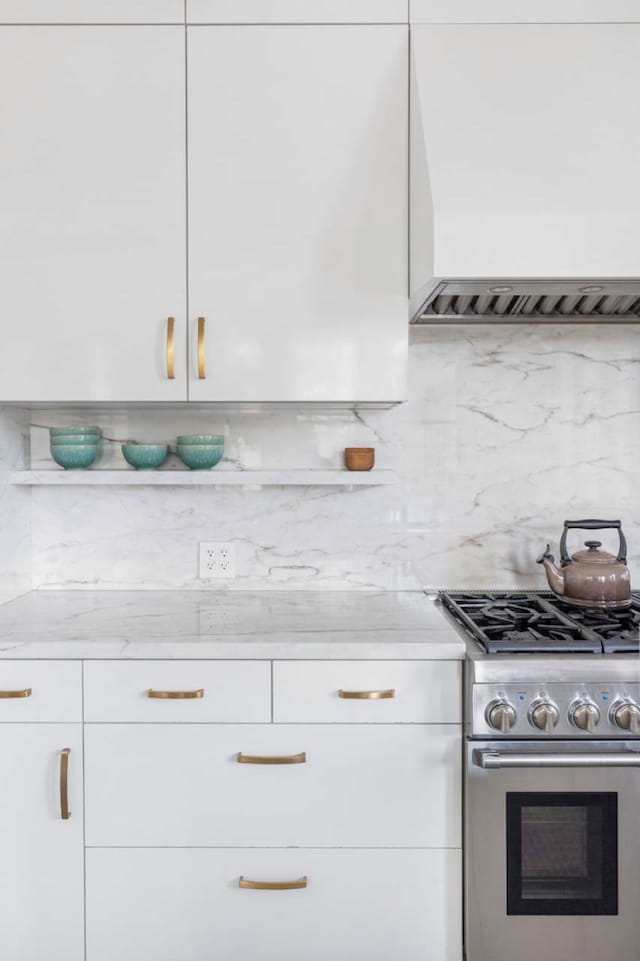 260 Park Ave S Unit 9Bc, New York City, NY 10003 - kitchen with high end stainless steel range, white cabinets, premium range hood, and modern cabinets