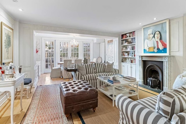 239 E 48th St, New York City, NY 10017 - living area with an inviting chandelier, built in features, wood finished floors, a fireplace, and recessed lighting