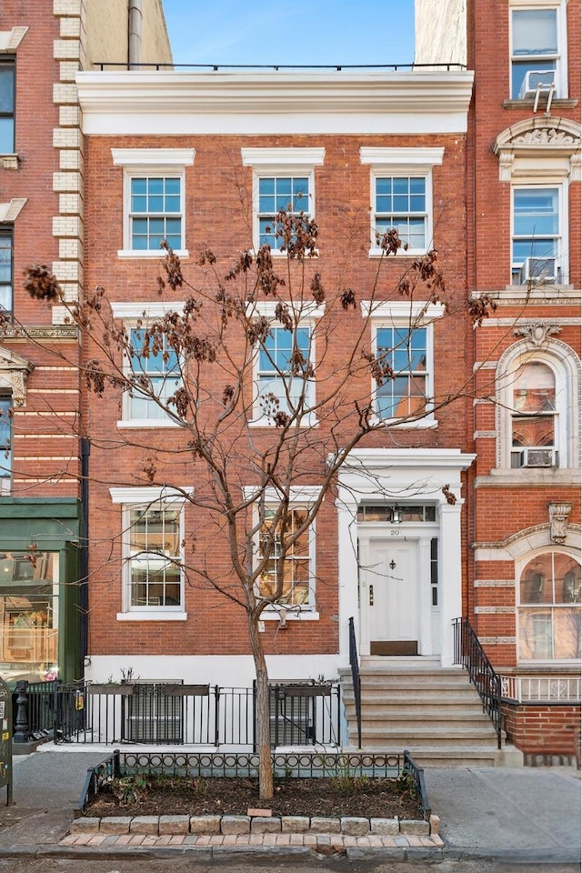 view of property featuring brick siding and a fenced front yard
