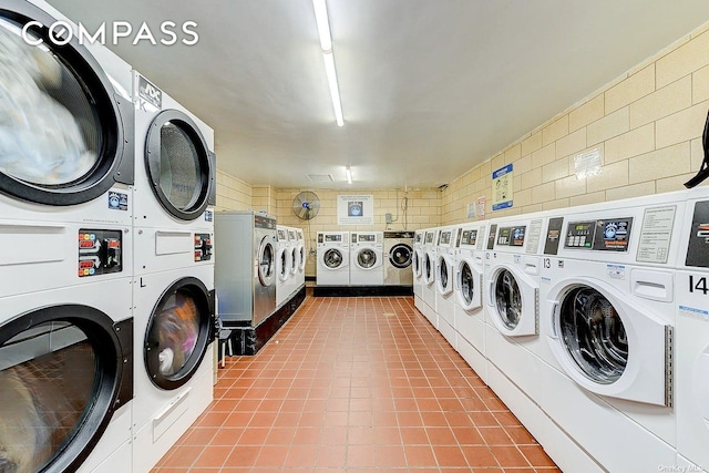 community laundry room with estacked washer and dryer, washer and dryer, and tile walls