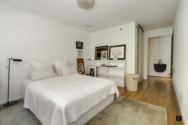 bedroom with wood finished floors and baseboards