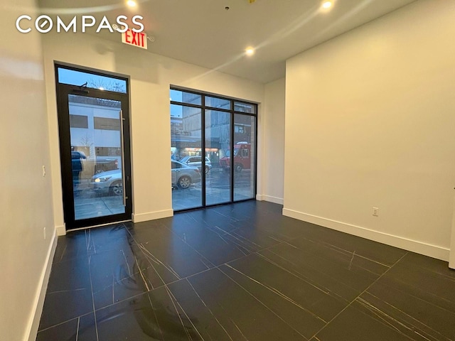 spare room with baseboards and recessed lighting