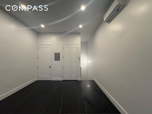 interior space with baseboards, dark wood-style floors, recessed lighting, a wall mounted AC, and electric panel