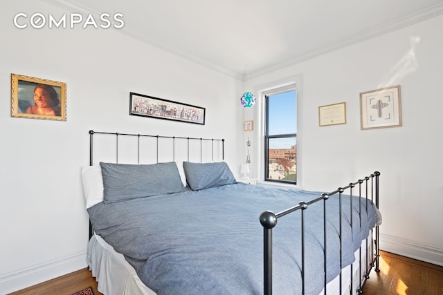 bedroom featuring baseboards, ornamental molding, and dark wood-type flooring