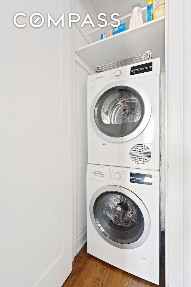 clothes washing area with stacked washer / dryer and wood finished floors