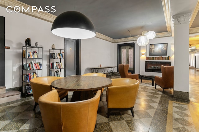 dining area featuring granite tiled floors, baseboards, ornamental molding, and a glass covered fireplace