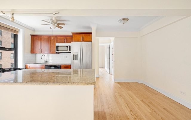 273 Bennett Ave Unit 5-G, New York City, NY 10040 - kitchen featuring stainless steel appliances, crown molding, light wood-style flooring, decorative backsplash, and a ceiling fan