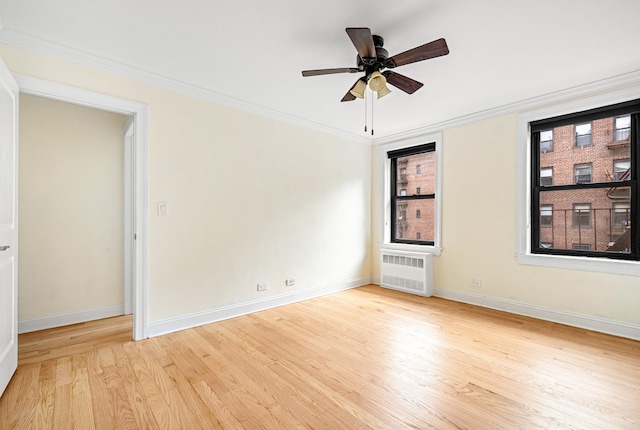 273 Bennett Ave Unit 5-G, New York City, NY 10040 - spare room featuring wood finished floors, baseboards, radiator, ceiling fan, and crown molding