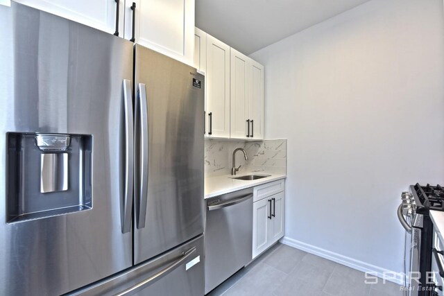 99 John St Unit 2504, New York City, NY 10038 - kitchen featuring stainless steel appliances, a sink, light countertops, white cabinets, and tasteful backsplash