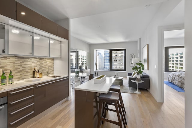 kitchen featuring light wood-type flooring, modern cabinets, backsplash, healthy amount of natural light, and recessed lighting
