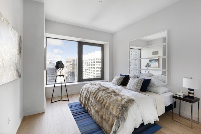 bedroom with wood finished floors and baseboards