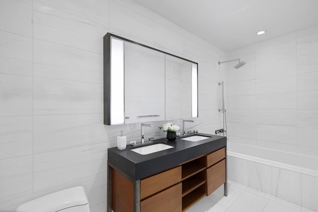 full bathroom featuring toilet, tile walls, double vanity, shower / bathtub combination, and tile patterned flooring
