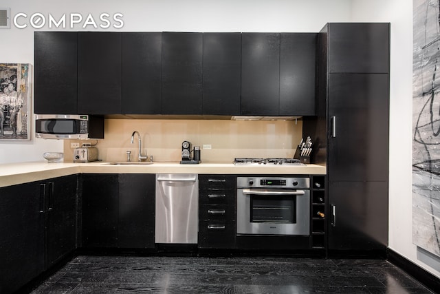 254 Park Ave S Unit 7P, New York City, NY 10010 - kitchen with appliances with stainless steel finishes, dark cabinets, a sink, light countertops, and modern cabinets