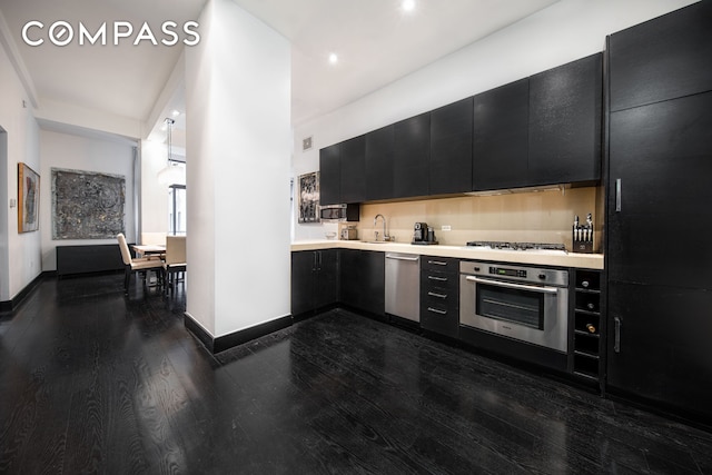 254 Park Ave S Unit 7P, New York City, NY 10010 - kitchen featuring appliances with stainless steel finishes, dark cabinetry, dark wood-type flooring, light countertops, and baseboards