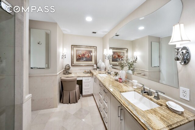 401 E 60th St Unit 35B, New York City, NY 10022 - bathroom with double vanity, recessed lighting, a wainscoted wall, tile patterned floors, and a shower with shower door
