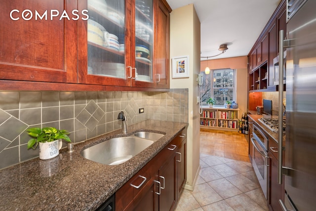 80 E End Ave Unit 3Hj, New York City, NY 10028 - kitchen with stainless steel appliances, backsplash, dark stone countertops, and glass insert cabinets