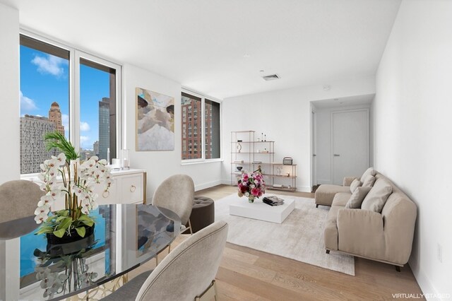 living area featuring a city view, visible vents, and wood finished floors