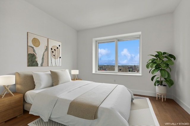 bedroom with wood finished floors and baseboards