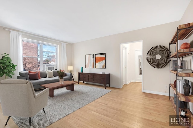 living area with light wood-type flooring, baseboards, and cooling unit