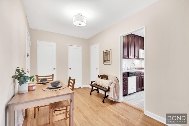dining room featuring baseboards and light wood-type flooring