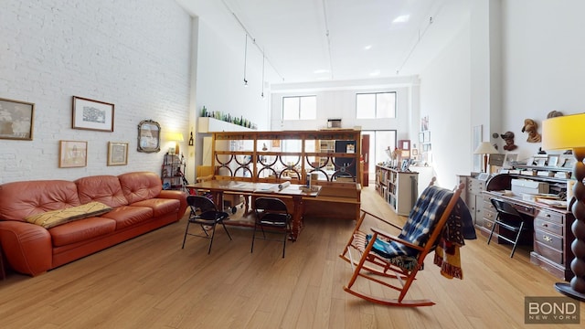 40 W 15th St Unit 1C, New York City, NY 10011 - home office with wood finished floors, a high ceiling, and brick wall