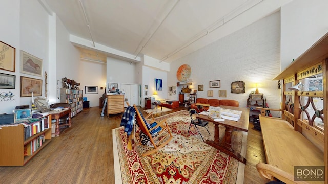 40 W 15th St Unit 1C, New York City, NY 10011 - living area featuring wood finished floors, a high ceiling, and brick wall