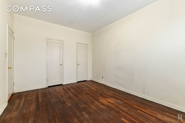 22-60 79th St Unit 1A, New York City, NY 11370 - unfurnished bedroom with dark wood-style flooring, multiple closets, and baseboards