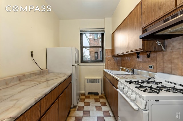 22-60 79th St Unit 1A, New York City, NY 11370 - kitchen with white appliances, radiator heating unit, under cabinet range hood, a sink, and brown cabinetry