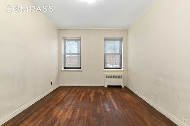 22-60 79th St Unit 1A, New York City, NY 11370 - spare room with radiator heating unit, wood-type flooring, and baseboards