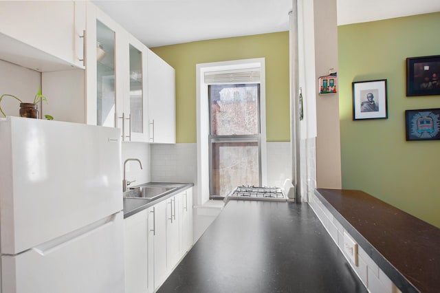 327 E 3rd St Unit 1-E, New York City, NY 10009 - kitchen with freestanding refrigerator, a sink, white cabinetry, tasteful backsplash, and glass insert cabinets