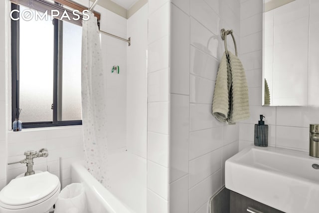 bathroom featuring tile walls, a wealth of natural light, a sink, and toilet