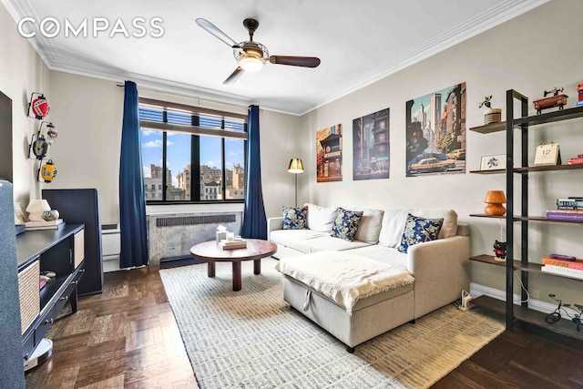 living area with radiator heating unit, a ceiling fan, crown molding, and baseboards