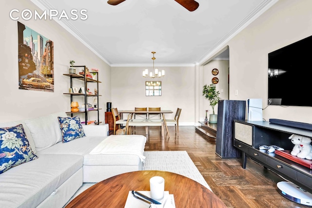 living room featuring baseboards, crown molding, and ceiling fan with notable chandelier