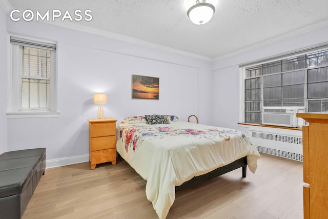 bedroom with cooling unit, a textured ceiling, radiator, wood finished floors, and ornamental molding