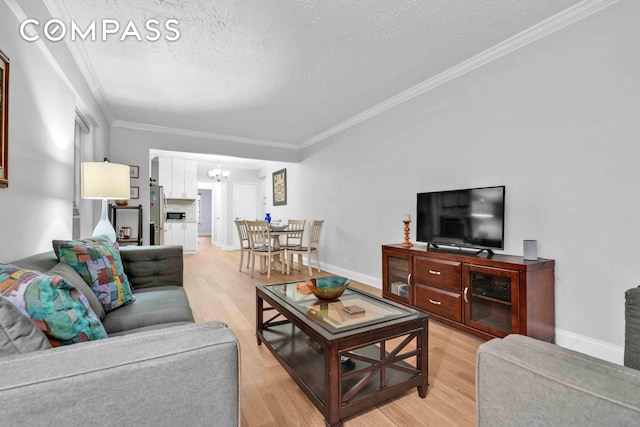 living area featuring a textured ceiling, light wood-type flooring, baseboards, a notable chandelier, and ornamental molding