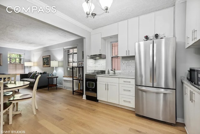 kitchen with light countertops, stainless steel appliances, a textured ceiling, and a sink