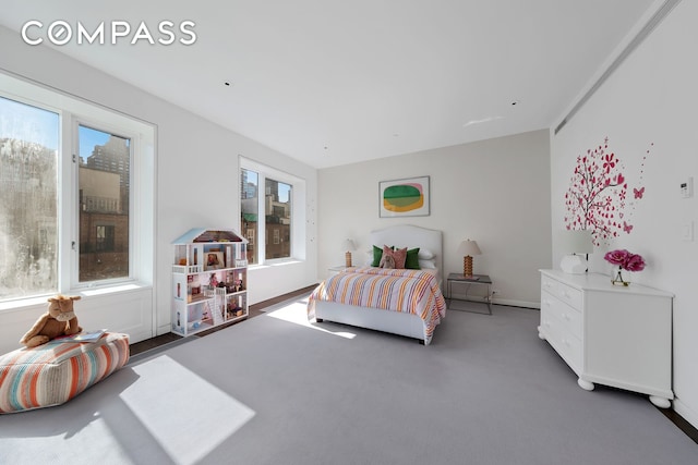 carpeted bedroom with baseboards and multiple windows
