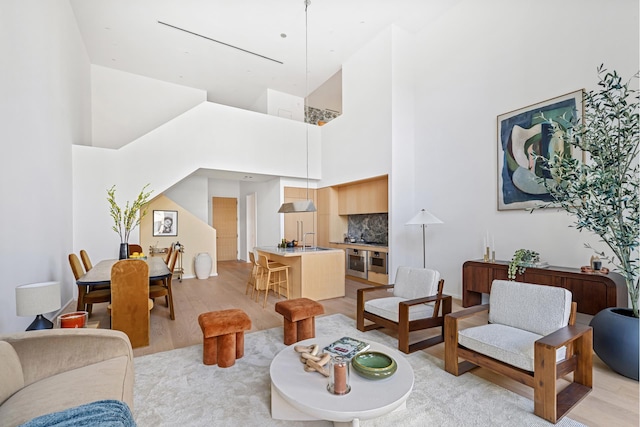 living room with light wood-type flooring and a high ceiling
