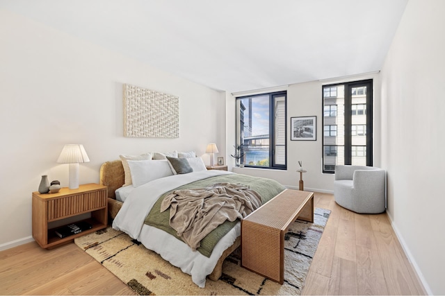 bedroom with baseboards and wood finished floors