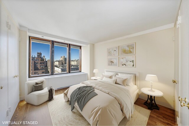 45 E 80th St Unit 17B, New York City, NY 10075 - bedroom with wood finished floors, crown molding, a city view, and baseboards